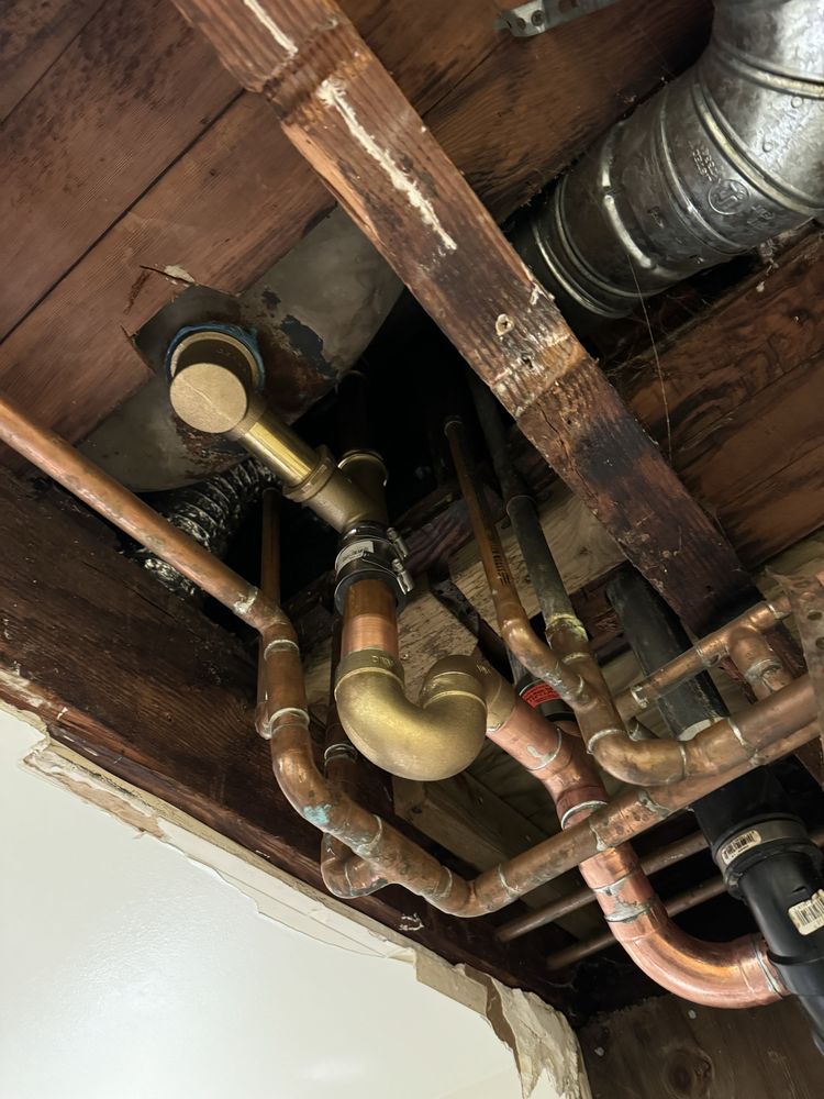 Copper drain and vent stack plumbing rough-in beneath floor joists